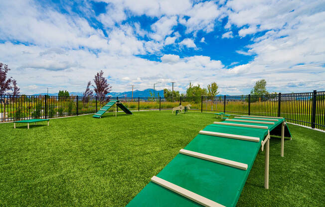 a playground with benches on the grass and a fence