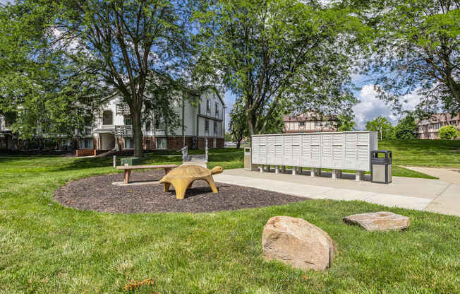 A park with a bench, a tree, and a rock