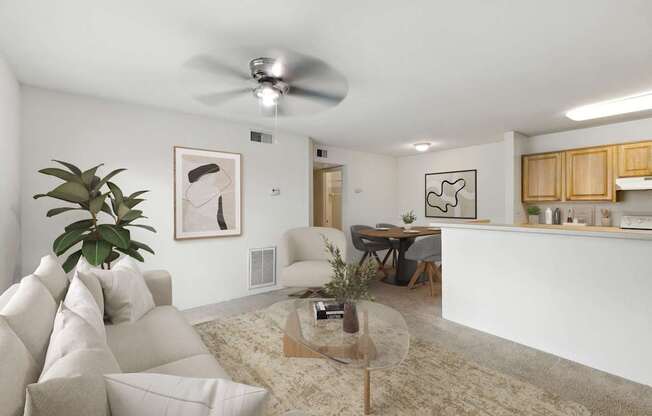 A living room with a white couch and a glass coffee table.
