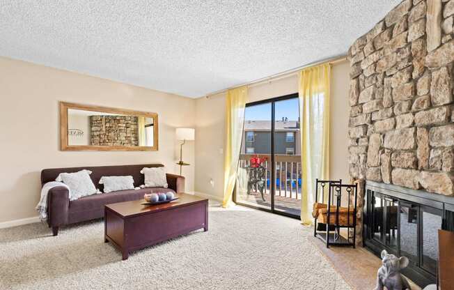 a living room with a stone fireplace and a couch