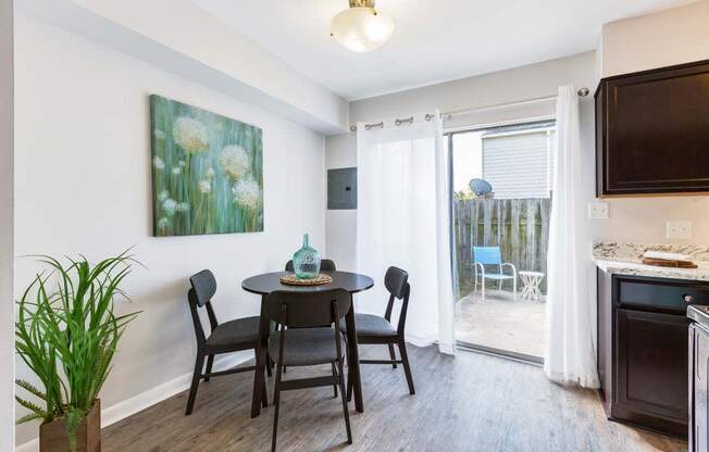 a dining area with a table and chairs and a sliding glass door