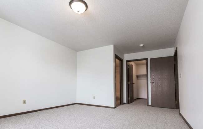 Grand Forks Primrose Apartments. A bedroom with white walls and carpet