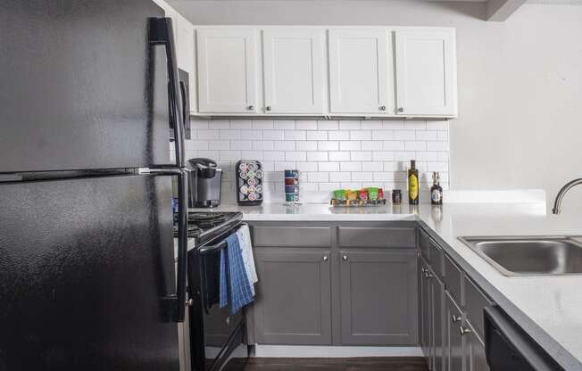 a kitchen with white cabinets and black appliances at Fifteen 98 Naperville, Naperville, 60563