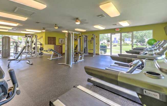 A gym with treadmills, weights, and exercise equipment.