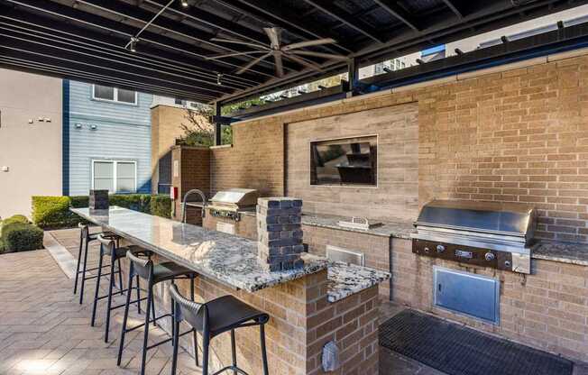 A patio with a barbecue grill and seating area.