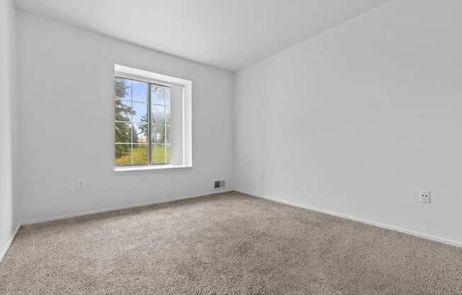 a bedroom with a window and carpet