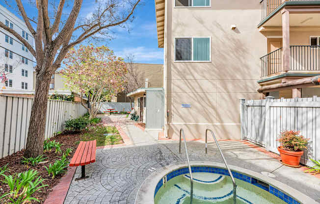 A small pool in a courtyard surrounded by a fence.