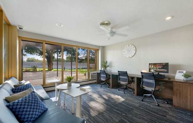 a living room with a couch and a desk with a clock on the wall