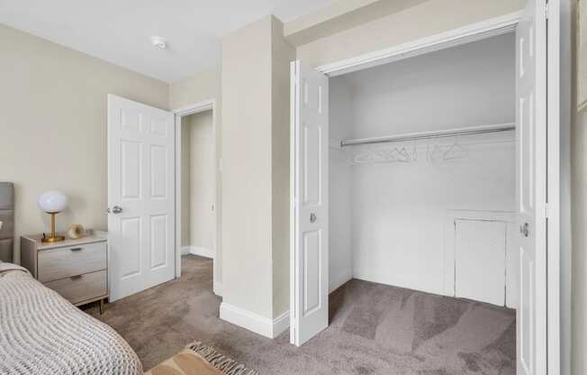 a bedroom with an open closet and a bed with white doors  at Parkview Towers, Collingswood, 08107