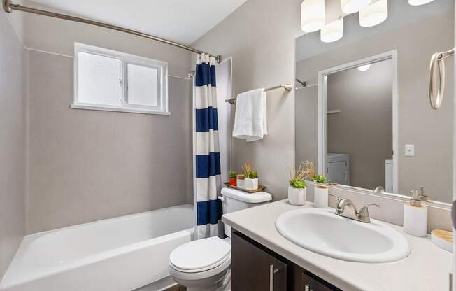 A bathroom with a white bathtub, toilet, and sink.