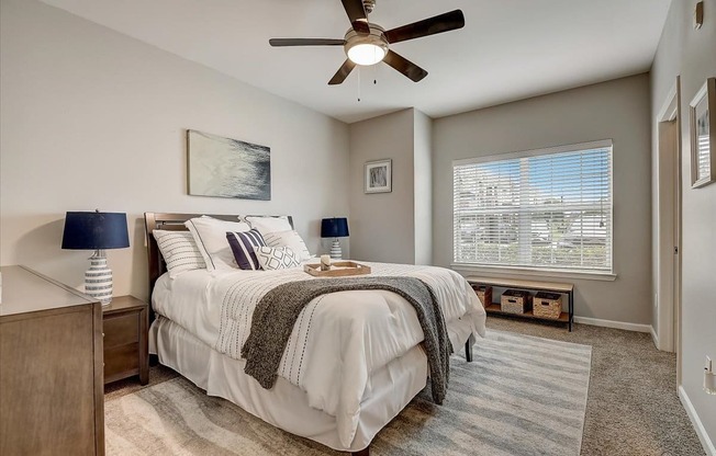 a bedroom with a bed and a ceiling fan