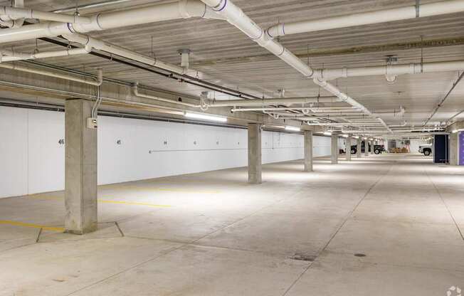 A large, empty parking garage with concrete floors and white walls.
