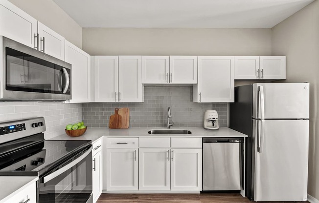 A modern kitchen with white cabinets and appliances.