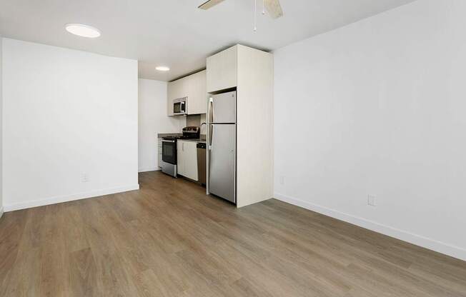 A kitchen with a refrigerator, oven, and microwave.