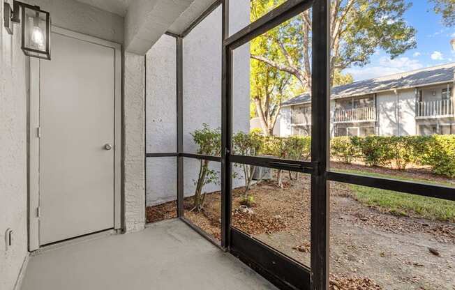 A patio with a white door and a black railing.