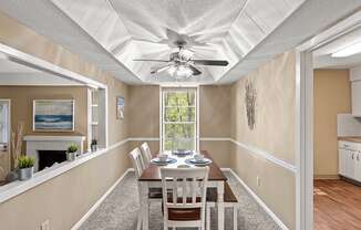 a dining room with a table and chairs and a ceiling fan