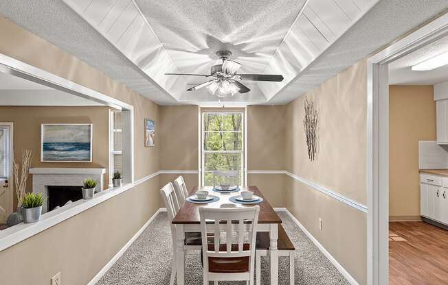 a dining room with a table and chairs and a ceiling fan