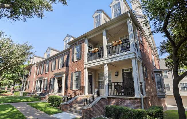 A large red brick house with a balcony and a small tower.