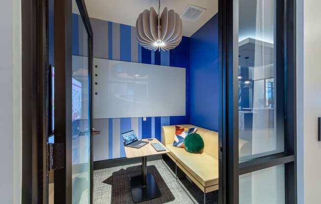 a desk with a laptop in a room with a window