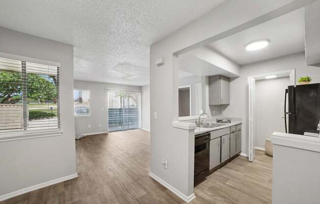 A kitchen with white cabinets and a black fridge.