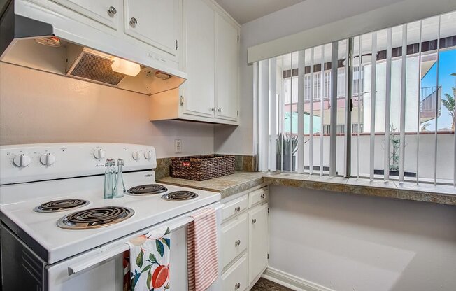 a kitchen with a stove top oven next to a window