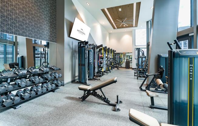 A modern fitness center at Modera McGavock, offering expansive training zones and advanced equipment.
