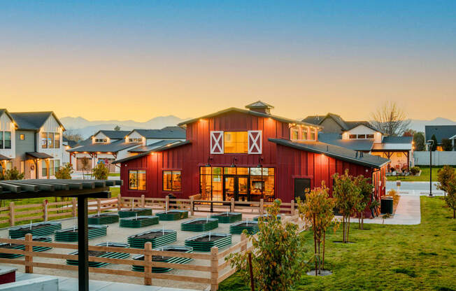 a red barn with an outdoor amphitheater at sunset