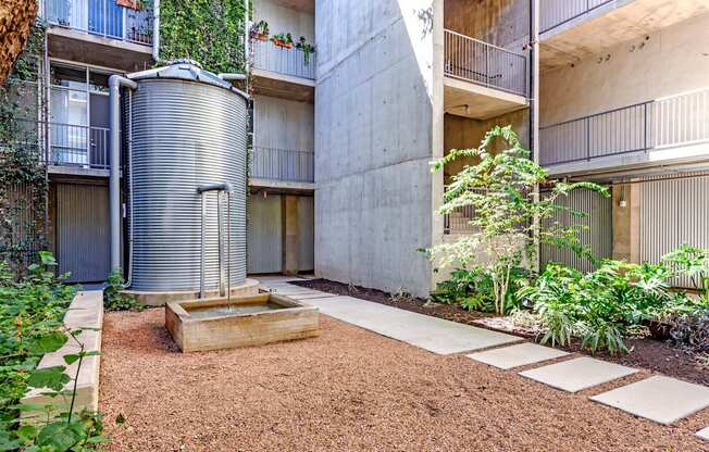 A courtyard with a water tank and a small tree.