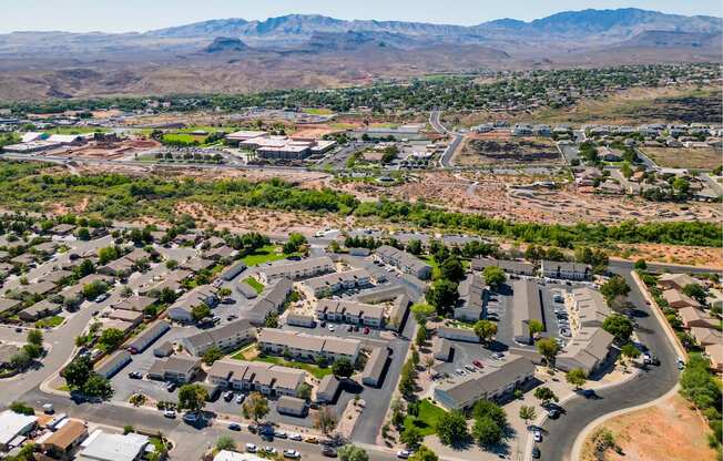 an aerial view of a city with cars parked in a parking lot