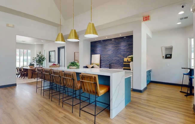 a kitchen with a long island with a bunch of chairs in front of it