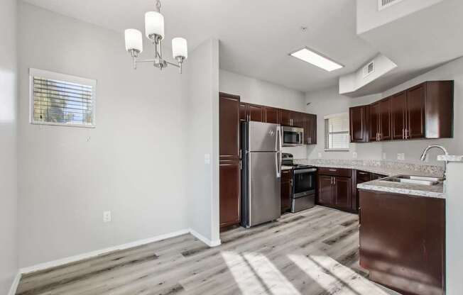 A kitchen with brown cabinets and a stainless steel refrigerator.