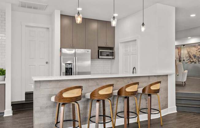 A kitchen with a white counter and bar stools.