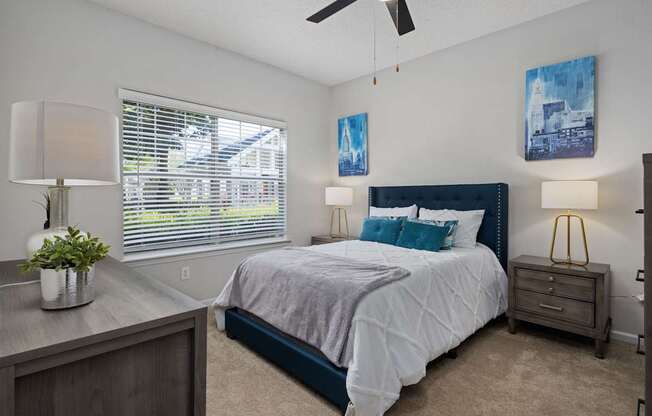 A bedroom with a bed, nightstand, and a ceiling fan.