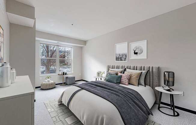 A bedroom with a large bed and a window overlooking a tree.