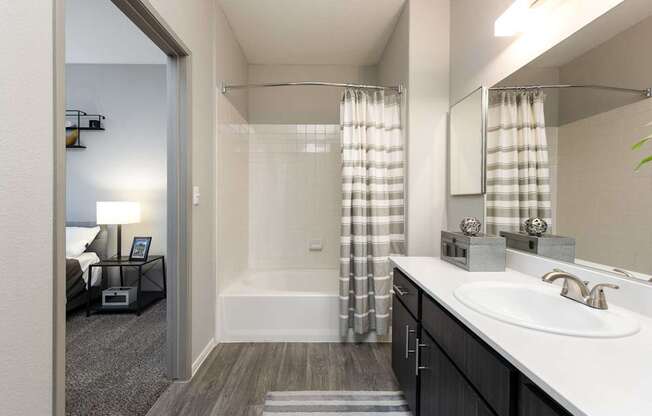 a bathroom with a shower and a sink and a mirror