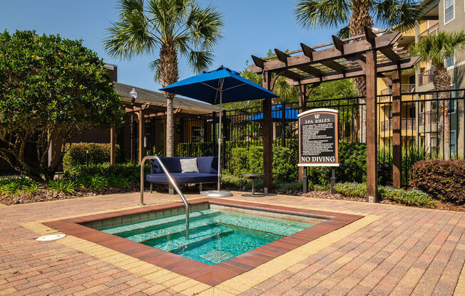 a small pool in a courtyard with a sign and a chair