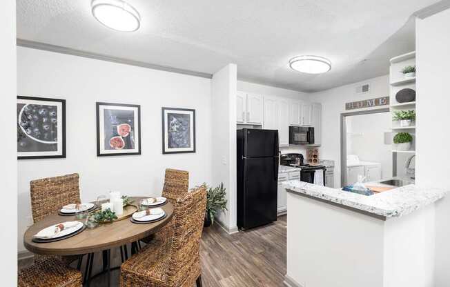 A kitchen with a table set for four and a refrigerator at The Palms at Chatham apartments in Savannah GA.