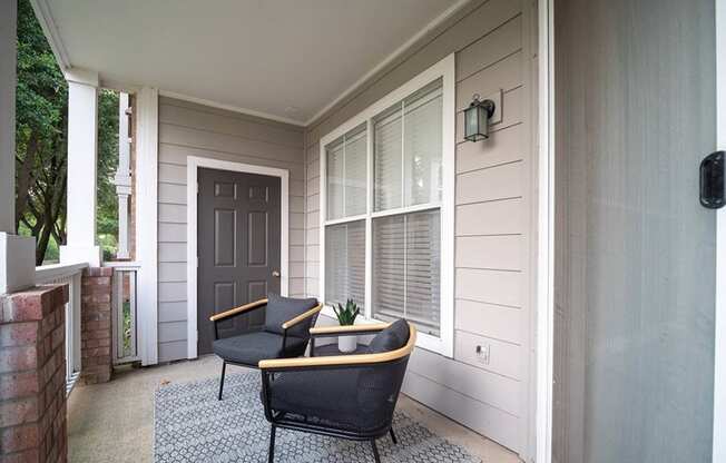 the front porch of a home with two chairs and a tableat Creekside at Legacy, Plano, 75024