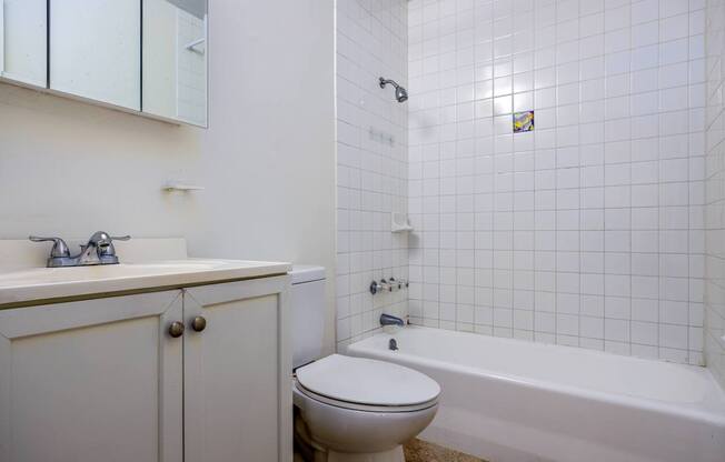 A white bathroom with a toilet, sink, and bathtub.