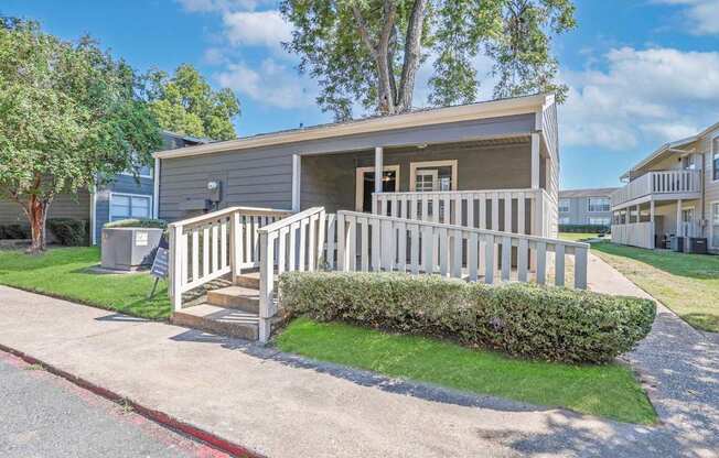 Exterior of our onsite laundry facility with a porch with a railing at Maplewood apartments in Shreveport, LA.