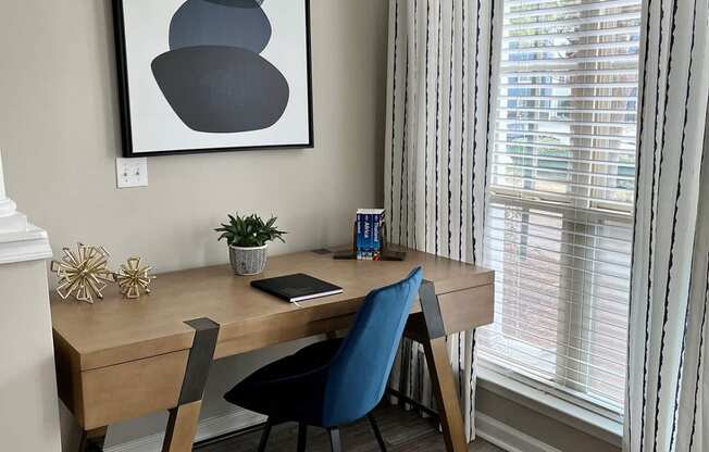 a home office with a desk and a painting on the wall