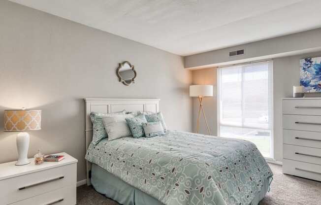 a bedroom with a bed and a window  at Bayville Apartments, Virginia Beach, Virginia