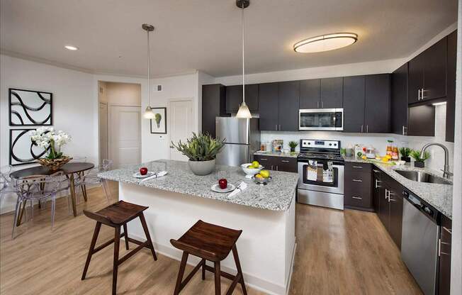 A modern kitchen with a center island and stools.