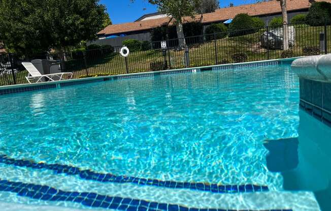 Inviting swimming pool and sun deck area with spa at Dove Ridge Apartments in Riverside, CA.