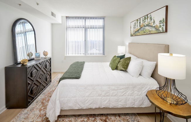 A tranquil retreat featuring new vinyl plank wood-style flooring that replaces old carpeting. The room is updated with contemporary lighting and continues the modern aesthetic found throughout the renovated apartment.