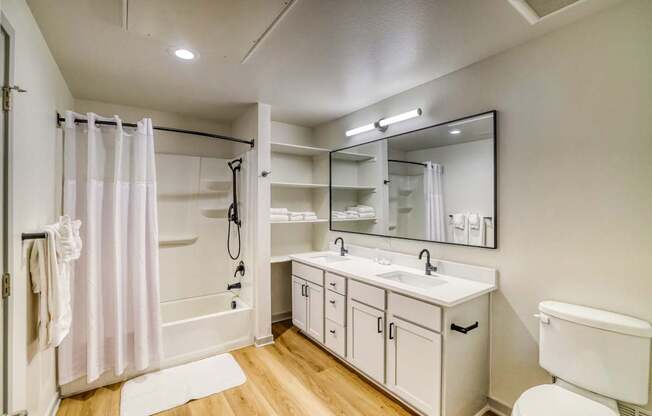 A white bathroom with a white toilet, sink, and bathtub.