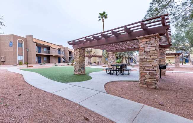 A patio with a table and chairs under a pergola.