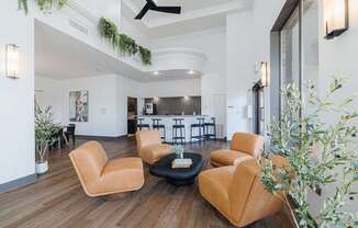 A living room with a black coffee table and tan chairs.