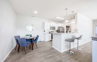 A kitchen with a white island and bar stools.