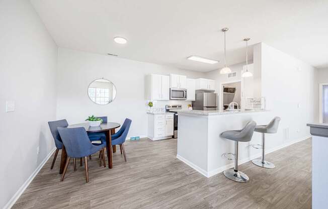 A kitchen with a white island and bar stools.